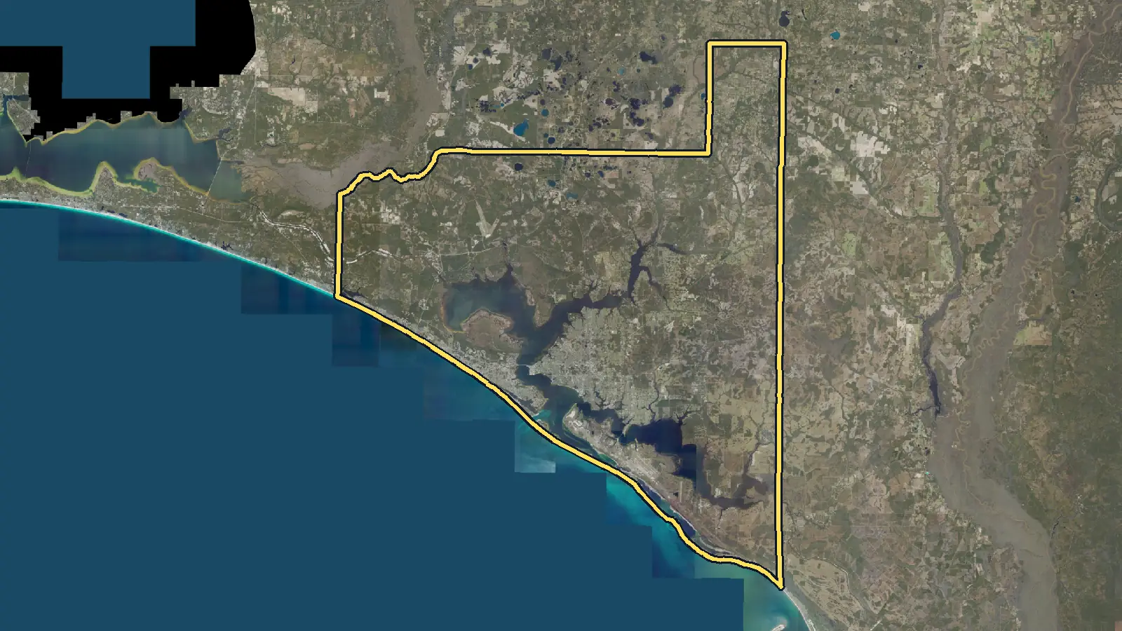 Aerial photo of Bay County, Florida, with the county's outline drawn on it